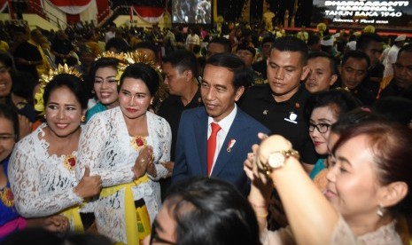 Presiden Joko Widodo berfoto bersama umat Hindu usai menghadiri acara Dharma Santi Nasional Perayaan Hari Raya Nyepi Tahun Baru Saka 1940 di GOR Ahmad Yani, Mabes TNI Cilangkap, Jakarta Timur, Sabtu (7/4). Dengan kostum yang sama, Presiden hari ini juga menghadiri acara Konvensi Nasional Galang Kemajuan (GK) Center di Kota Bogor, Jawa Barat.