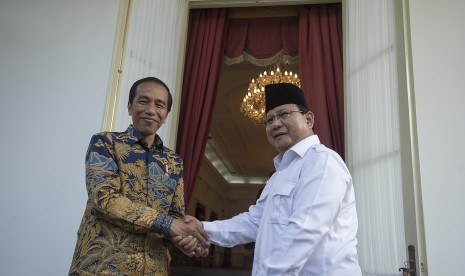 Presiden Joko Widodo berjabat tangan dengan Ketua Umum DPP Partai Gerakan Indonesia Raya Prabowo Subianto (kanan) seusai memberikan keterangan pers di teras belakang Istana Merdeka, Jakarta, Kamis (17/11).