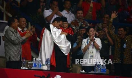 Presiden Joko Widodo bersama Ketua Umum Pengurus Besar Ikatan Pencak Silat Seluruh Indonesia Prabowo Subianto dan Pesilat Indonesia Hanifan Yudani Kusumah berpelukan usai pertandingan cabang olahraga silat Asian Games 2018 di Padepokan Pencak Silat TMII, Jakarta, Rabu (29/8).