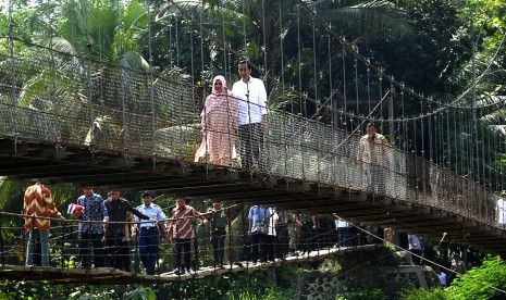 Presiden Joko Widodo bersama Ny Iriana Jokowi melewati jembatan gantung saat kunjungannya ke Lebak membagikan sembako dan uang kepada warga kurang mampu beberapa waktu lalu. (ilustrasi)