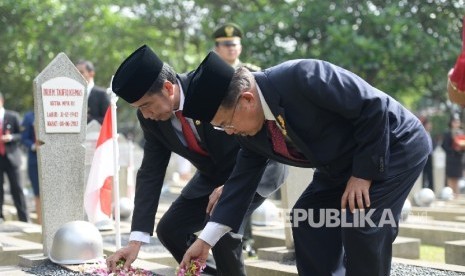  Presiden Joko Widodo bersama Wakil Presiden Jusuf Kalla melakukan tabur bunga usai Upacar Ziarah Nasional di Taman Makam Pahlawan Nasional Kalibata, Jakarta, Kamis (10/11). 