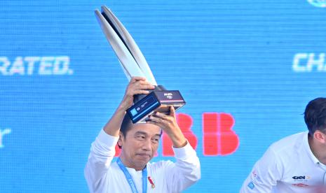 Presiden Joko Widodo bersiap menyerahkan piala ke pembalap Jaguar TCS Mitch Evans di podium usai memenangkan seri kesembilan Formula E di Jakarta International E-Prix Circuit (JEIC) Ancol, Jakarta, Sabtu (4/6/2022).