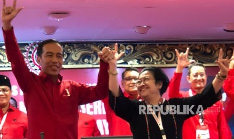   Chairwoman of the Indonesian Democratic Party of Struggle (PDI-P) Megawati Soekarnoputri holds Joko Widodo's hand after re-appointing him as the presidential candidate for 2019 election.