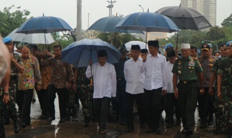 Presiden Joko Widodo dan Wakil Presiden Jusuf Kalla berjalan kaki dari Istana Merdeka menuju Monas untuk melaksanakan shalat Jumat bersama jutaan ummat yang ikut dalam Aksi Super Damai Bela Islam Jilid III, Jumat (2/12). 