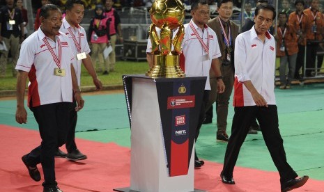 Presiden Joko Widodo didampingi Kapolri Jenderal Pol Badrodin Haiti (kiri), Panglima TNI Jenderal TNI Gatot Nurmantyo (kedua kanan), dan Menpora Imam Nahrawi (kedua kiri) berjalan menuju lapangan saat akan membuka laga final Piala Bhayangkara antara Arema 