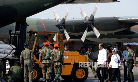 Presiden Joko Widodo didampingi Menlu Retno Marsudi melihat persiapan pengiriman bantuan kemanusiaan untuk pengungsi Rohingya di Pangkalan TNI AU, Bandara Halim Perdanakusumah, Jakarta, Rabu (13/9).