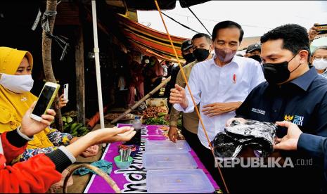 BAGI KAOSNYA DONG, PAK. Presiden Joko Widodo didampingi Menteri BUMN Erick Thohir membagikan bantuan langsung tunai (BLT) kepada para pedagang di Pasar Baru Tanjung Enim, Kabupaten Muara Enim, Sumatra Selatan, Senin (24/1/2022).