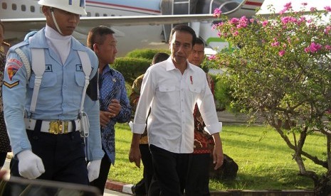 Presiden Joko Widodo didampingi Plt Gubernur Aceh, Soedarmo (kedua kiri) berjalan bersama saat tiba di Bandara Sultan Iskandar Muda, Aceh Besar, Aceh, Kamis (8/12). 