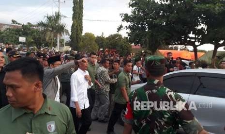 Presiden Joko Widodo (Jokowi) bersama Gubernur NTB TGB Zainul Majdi meninjau posko utama penanganan darurat bencana di lapangan Tanjung, Kabupaten Lombok Utara, NTB, Senin (13/8).