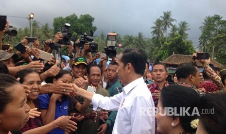 Presiden Joko Widodo (Jokowi) memberikan bantuan kepada para pengungsi erupsi Gunung Agung di lapangan Desa Ulakan, Karangasem, Bali, Selasa (26/9). 