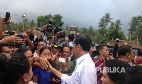 Presiden Joko Widodo (Jokowi) memberikan bantuan kepada para pengungsi erupsi Gunung Agung di lapangan Desa Ulakan, Karangasem, Bali, Selasa (26/9). 