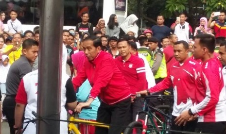 Presiden Joko Widodo (Jokowi) pagi ini mengayuh sepedanya dari Istana Merdeka menuju lokasi penyerahan sertifikat hak atas tanah di Lapangan Park&Ride; Jalan MH Thamrin, Jakarta Pusat, Ahad (20/8). 