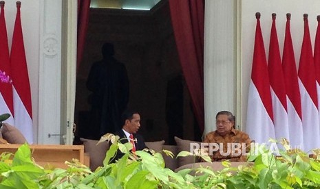 Presiden Joko Widodo (Jokowi) berbincang dengan Presiden ke-RI Susilo Bambang Yudhoyono (SBY) di veranda halaman tengah Istana, Jakarta, Jumat (27/10). 