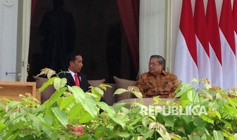 Presiden Joko Widodo (Jokowi) tengah berbincang dengan Presiden keenam Susilo Bambang Yudhoyono (SBY) di veranda halaman tengah Istana, Jakarta, Jumat (27/10). 