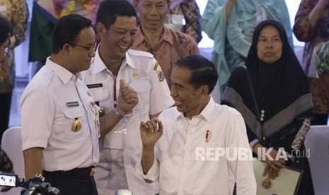 Presiden Joko Widodo (kanan) berbincang dengan Gubernur DKI Jakarta Anies Baswedan (kiri) dan Wali Kota Jakarta Barat Rustam Effendi (tengah) usai menyerahkan Sertifikat Tanah untuk Rakyat di Cengkareng, Jakarta, Rabu (9/1/2019).