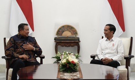 Presiden Joko Widodo (kanan) berbincang dengan mantan Presiden Susilo Bambang Yudhoyono dalam pertemuan di Istana Merdeka, Jakarta, Kamis (10/10).