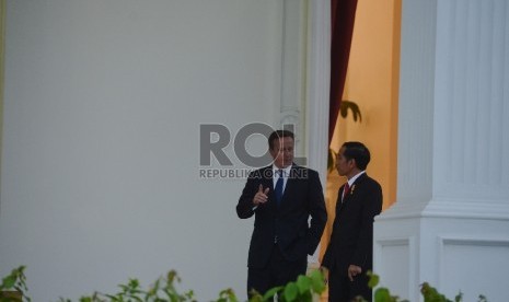 Presiden Joko Widodo (kanan) berbincang dengan Perdana Menteri Inggris David Cameron (kiri) di teras Istana Merdeka, Jakarta, Senin (27/7).