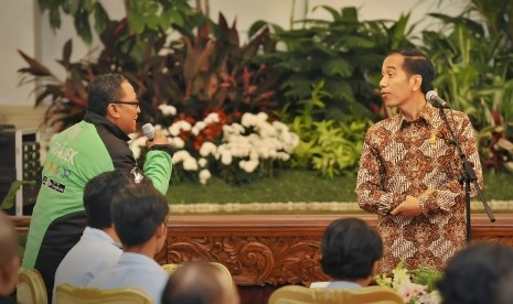 Presiden Joko Widodo (kanan) berdialog dengan pengendara Gojek saat pertemuan bersama pengemudi kendaraan umum di Istana Negara, Jakarta, Selasa (2/9). 