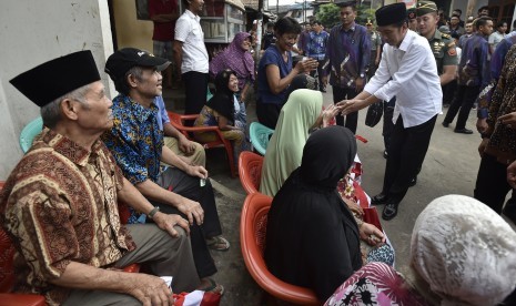 Presiden Joko Widodo (kanan) berjabat tangan dengan lansia saat membagikan paket sembako kepada warga. ilustrasi