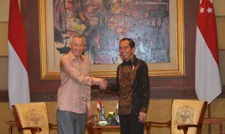 Presiden Joko Widodo (kanan) berjabat tangan dengan Perdana Menteri Singapura Lee Hsien Loong (kiri) saat mengadakan pertemuan bilateral di sela Pertemuan Tahunan IMF - World Bank Group 2018 di Nusa Dua, Bali, Kamis (11/10).