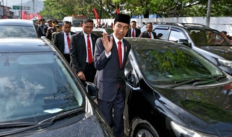 Presiden Joko Widodo (kanan) berjalan kaki di antara kendaraan yang terjebak kemacetan menuju lokasi Upacara Parade dan Defile HUT ke-72 TNI Tahun 2017 di Dermaga Indah Kiat, Cilegon, Banten Kamis (5/10). 