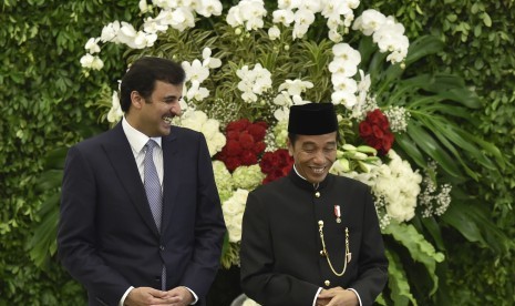 Presiden Joko Widodo (kanan) bersama Emir Qatar Sheikh Tamim bin Hamad Al Thani (kiri) tertawa disela-sela menyaksikan penandatanganan kerja sama kedua negara di Istana Bogor, Jawa Barat, Rabu (18/10).