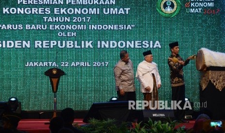 Presiden Joko Widodo (kanan) bersama Ketua MUI Ma'ruf Amin (tengah) dan Menteri Koordinator Perekonomian Darmin Nasution (kiri) menabuh bedug saat membuka Kongres Ekonomi Umat 2017 di Jakarta, Sabtu (22/4).