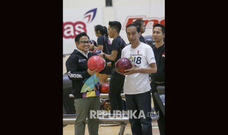 Presiden Joko Widodo (kanan) bersama Panglima Santri Nusantara Muhaimin Iskandar (kiri) mengangkat bola boling saat mencoba lintasan arena Jakabaring Boling Center, Palembang, Sumateran Selatan, Sabtu (14/7). 