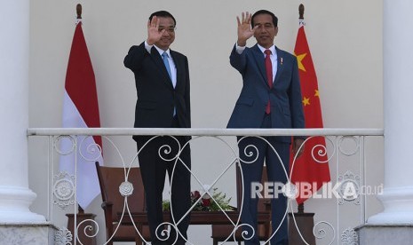 Presiden Joko Widodo (kanan) bersama Perdana Menteri Cina Li Keqiang (kiri) melambaikan tangan kepada jurnalis di beranda Istana Bogor, Jawa Barat, Senin (7/5). 