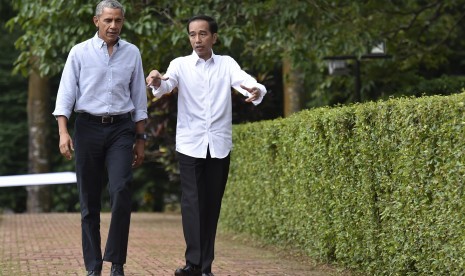 Presiden Joko WIdodo (kanan) bersama Presiden ke-44 Amerika Serikat Barack Obama (kiri) berjalan menuju Cafe Grand Garden Kebun Raya Bogor, Jawa Barat, Jumat (30/6). 