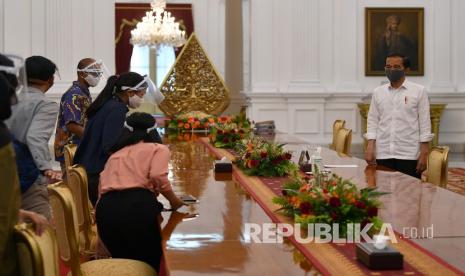 Presiden Joko Widodo (kanan) bersiap menemui wartawan di Istana Merdeka, Jakarta, Senin (13/7/2020). Presiden menyatakan pemerintah sedang menyiapkan regulasi berupa sanksi bagi pelanggar protokol kesehatan. Presiden juga menyampaikan puncak pandemi COVID-19 diperkirakan terjadi pada Agustus atau September mendatang.