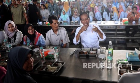 Presiden Joko Widodo (kanan) bersiap untuk makan bersama saat mengunjungi pabrik sepatu PT KMK Global Sports I, Tangerang, Banten, Selasa (30/4/2019).