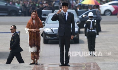 Presiden Joko Widodo (kanan) beserta Ibu Negara Iriana Joko Widodo (kiri) memberi hormat saat tiba untuk memimpin prosesi pemakaman almarhum Presiden ke-3 Republik Indonesia BJ Habibie di Taman Makam Pahlawan Nasional Utama (TMP) Kalibata, Jakarta, Kamis (12/9/2019).