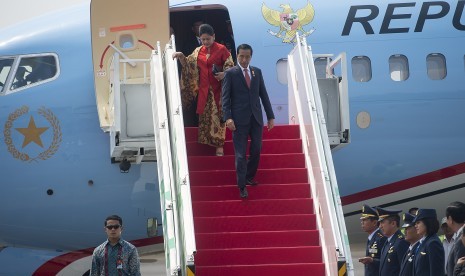 President Joko Widodo and first lady Iriana Joko Widodo walk down the stairs of presidential airplane. (Illustration).