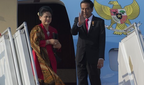 Presiden Joko Widodo (kanan) dan Ibu Negara Ny. Iriana Widodo melambaikan tangan sebelum masuk ke pesawat kepresidenan di Bandara Internasional Halim Perdanakusuma, Jakarta Timur, Selasa (28/7). 