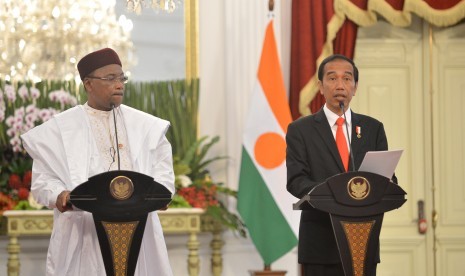 Presiden Joko Widodo (kanan) dan Presiden Republik Niger Mahamadou Issoufou  (kiri) memberikan keterangan kepada wartawan seusai melakukan pertemuan bilateral di Istana Merdeka, Jakarta, Senin (16/10). 