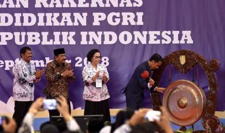 Presiden Joko Widodo (kanan) didampingi Gubernur Jawa Timur Soekarwo (kedua kiri), Rektor Universitas PGRI Surabaya Djoko Adi Waludjo (kiri) dan Ketua Pengurus Besar PGRI Unifah Rosyidi (kedua kanan) memukul gong ketika membuka rapat kerja nasional (rakernas) lembaga pendidikan PGRI usai memberikan kuliah umum wawasan kebangsaan di Universitas PGRI Adi Buana Surabaya, Jawa Tmur, Kamis (6/9).