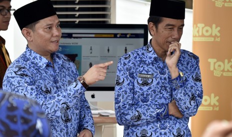 Presiden Joko Widodo (kanan) didampingi Ketua Umum Dewan Pimpinan Nasional Korpri, Zudan Arif Fakhrulloh (kiri) meninjau stan toko online KORPRI disela-sela peringatan HUT ke-45 KORPRI di Monumen Nasional, Jakarta, Selasa (29/11).