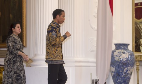 Presiden Joko Widodo (kanan) didampingi Menko PMK Puan Maharani (kiri) berjalan menuju ruang jumpa pers di Istana Merdeka, Jakarta, Kamis (10/3). 