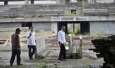 Presiden Joko Widodo didampingi Menpora Imam Nahrawi, Menteri PU dan Perumahan Rakyat Basuki Hadimuljono serta Staf Khusus Presiden Johan Budi meninjau lokasi Proyek Wisma Atlet di Bukit Hambalang,Kabupaten Bogor, Jumat (18/3). 