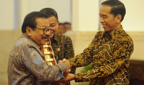 Presiden Joko Widodo (kanan) didampingi Menhub Ignasius Jonan (tengah) menyerahkan penghargaan Wahana Tata Nugraha Wiratama Kencana 2015 kepada Gubernur Jawa Timur Soekarwo (kiri) di Istana Negara, Jakarta, Rabu (23/12).  (Antara/Puspa Perwitasari)