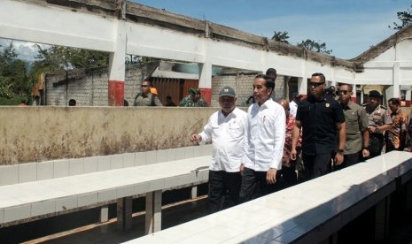 Presiden Joko Widodo (kanan) didampingi Menteri PUPR Basuki Hadimuljono (kiri) meninjau kondisi Pasar Wouma yang terbakar saat kerusuhan lalu di Wamena, Kabupaten Jayawijaya, Papua, Senin (28/10/2019).