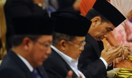 Presiden Joko Widodo (kanan) didampingi Wakil Presiden Jusuf Kalla (tengah) dan Menteri Agama Lukman Hakim Syaifuddin (kiri) memanjatkan doa dalam peringatan Maulid Nabi Muhammad SAW 1437 Hijriah di Istana Negara, Jakarta, Rabu (23/12).