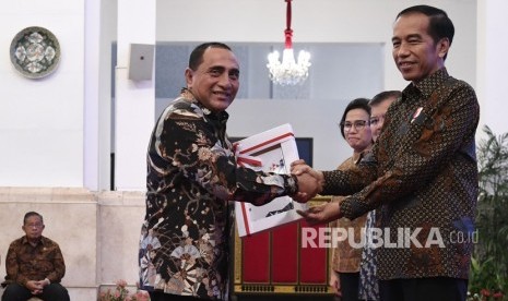 Presiden Joko Widodo (kanan) didampingi Wakil Presiden Jusuf Kalla (kedua kanan) dan Menkeu Sri Mulyani menyerahkan Daftar Isian Pelaksanaan Anggaran (DIPA) dan Daftar Alokasi Transfer Daerah dan serta Dana Desa kepada Gubernur Sumatera Utara Edy Rahmayadi di Istana Negara, Jakarta, Selasa (11/12/2018). 