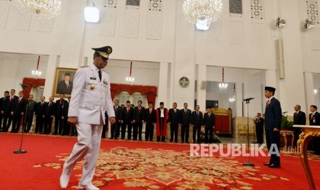 Presiden Joko Widodo (kanan) melantik Wakil Gubernur Kepulauan Riau Isdianto di Istana Negara, Jakarta, Selasa (27/3).  Wali Kota Tanjungpinang, Rahma, menjalani karantina mandiri di rumah dinasnya setelah menjalani tes usap karena berkontak erat dengan Gubernur Isdianto dan Sy, mantan pejabat Kepri yang positif Covid-19.