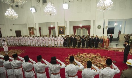 Presiden Joko Widodo (kanan) membalas hormat dari pasukan pengibar bendera pusaka dalam pengukuhan pasukan pengibar bendera pusaka (Paskibraka) 2017 di Istana Negara, Jakarta, Selasa (15/8). 