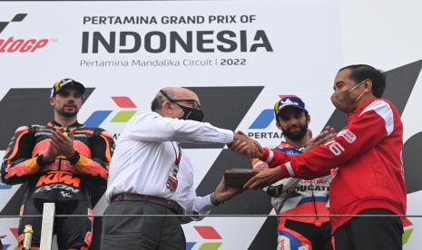 Presiden Joko Widodo (kanan) memberikan cenderamata kepada CEO Dorna Sports Carmelo Ezpeleta (kedua kiri) disaksikan pembalap Red Bull KTM Factory Racing Miguel Oliveira (kiri) dan pembalap Pramac Racing Johann Zarco (kanan) di podium seusai balapan MotoGP seri Pertamina Grand Prix of Indonesia di Pertamina Mandalika International Street Circuit, Lombok Tengah, NTB, Ahad (20/3/2022).