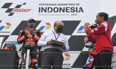 Presiden Joko Widodo (kanan) memberikan cenderamata kepada CEO Dorna Sports Carmelo Ezpeleta (kedua kiri) disaksikan pembalap Red Bull KTM Factory Racing Miguel Oliveira (kiri) di podium seusai balapan MotoGP seri Pertamina Grand Prix of Indonesia di Pertamina Mandalika International Street Circuit, Lombok Tengah, NTB, Ahad (20/3/2022). Pembalap yang berpartisipasi di Pertamina Grand Prix of Indonesia atau MotoGP Mandalika 2022 mendapat cenderamata berupa bumbu/bahan masakan/minuman khas Indonesia, sebagai upaya pemerintah untuk mempromosikan produk UMKM dan IKM lokal.