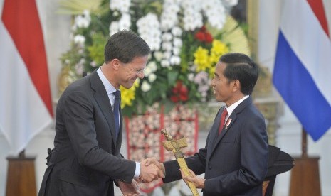 Presiden Joko Widodo (kanan) menerima artefak berupa keris dari Perdana Menteri Kerajaan Belanda Mark Rutte (kiri) saat kunjungan kerja di Istana Merdeka, Jakarta, Rabu (23/11). 