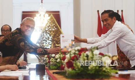 Presiden Joko Widodo (kanan) menerima buku laporan penyelenggaraan Pemilu Serentak tahun 2019 dari Ketua Komisi Pemilihan Umum (KPU) Arief Budiman dalam pertemuan di Istana Merdeka, Jakarta, Senin (11/11/2019). 